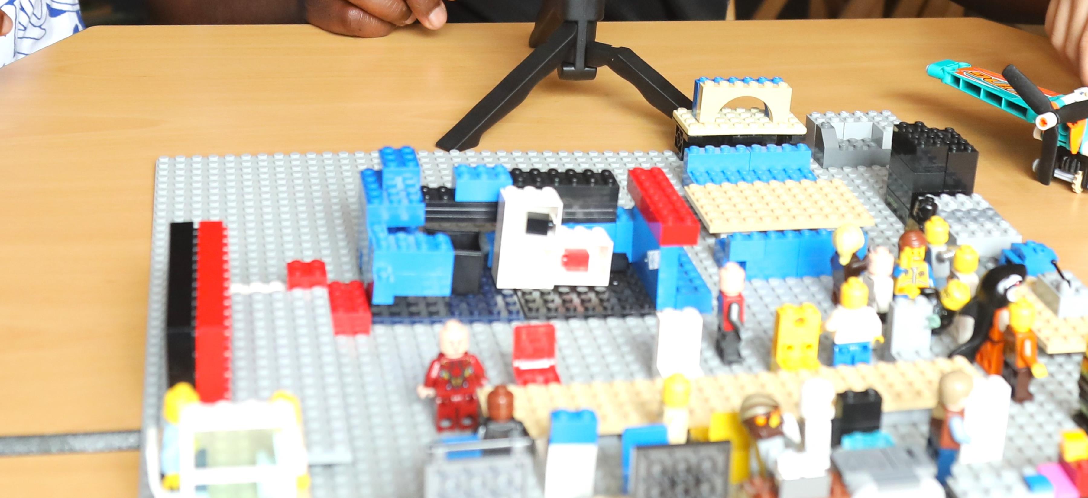 A LEGO movie set on a table with a camera tripod ready for animation